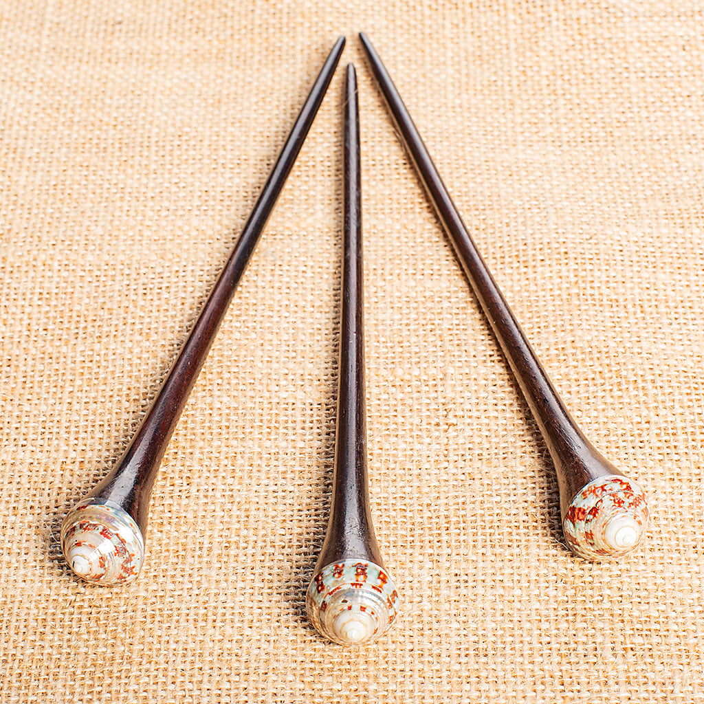 thin tapering wooden hair stick with pointed spiral shell on end