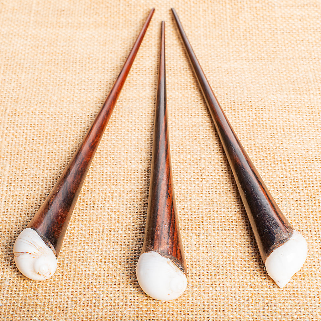 thin cone shaped wooden hair stick with white rounded shell at end