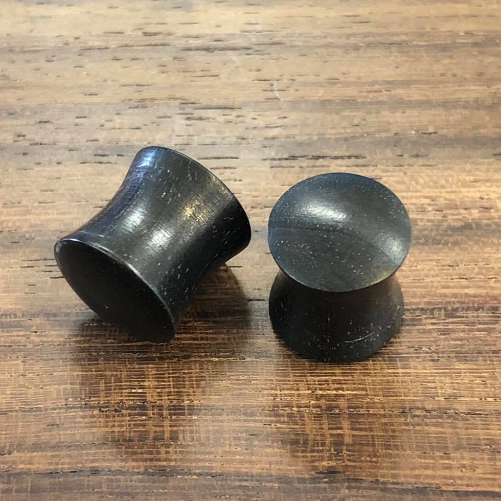 Two black plugs on a wooden background