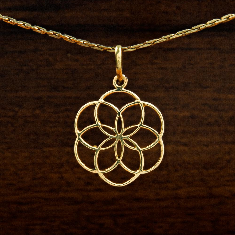 A Brass pendant decorated with a flower of life symbol