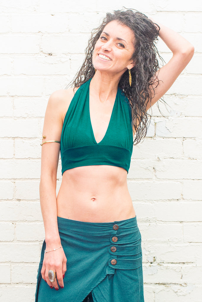 Model wearing a crop top in teal colour on a white background