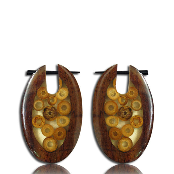 Two earrings made of narra wood featuring oval shapes on a white background