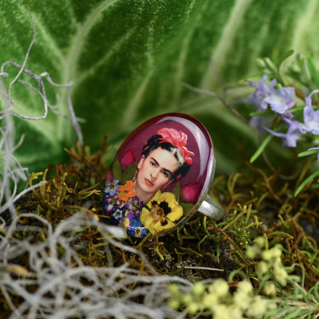 san marco silver and resin adjustable ring with photograph of frida kahlo wearing a red hair bow with colourful dried flowers and set in resin