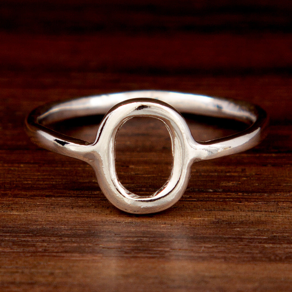 A silver ring featuring an oval shape on a wooden background