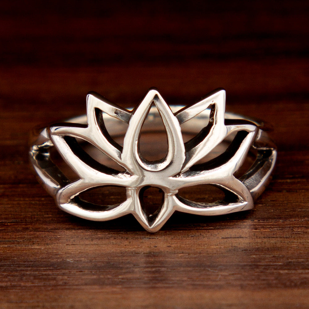 A 925 sterling silver ring featuring a Lotus Flower design on a wooden background