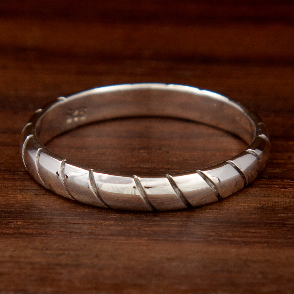 A silver ring featuring stripes along the ring