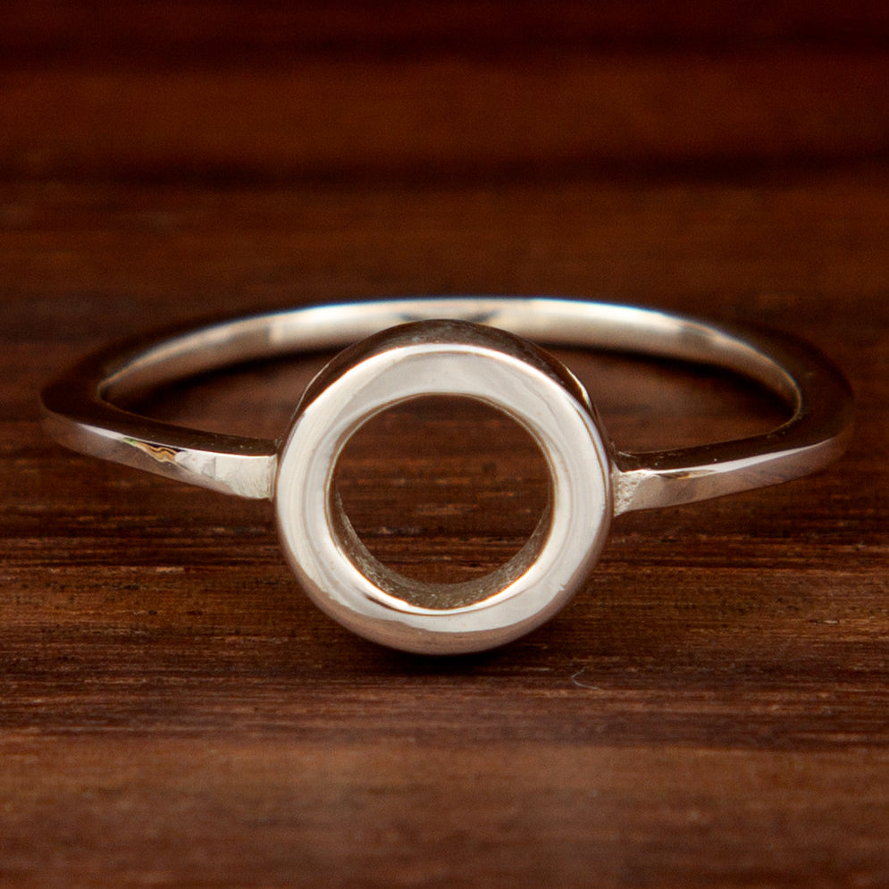 Sterling silver ring featuring a circle shape on a wooden background
