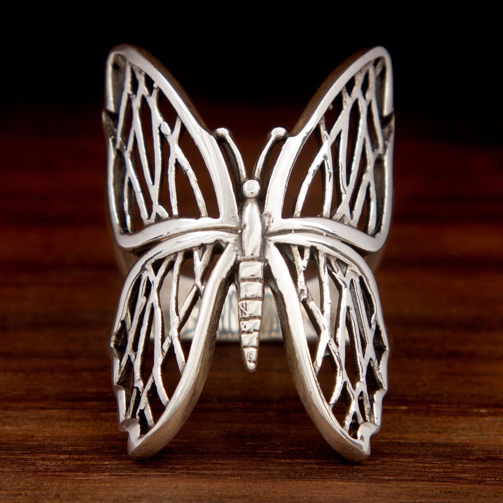 A 925 sterling silver ring featuring a Butterfly design on a wooden background