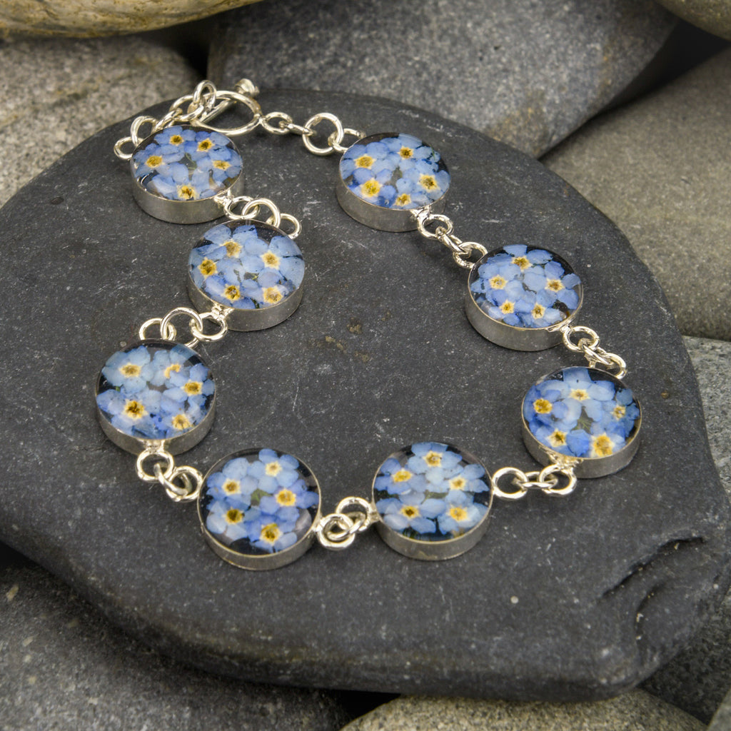 san marco silver and resin bracelet with dried blue flowers encased in the resin of eight small round sections and joined by silver links