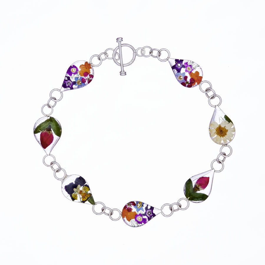 san marco silver and resin bracelet with various coloured dried flowers encased in the resin of seven small droplet shaped sections and joined by silver links