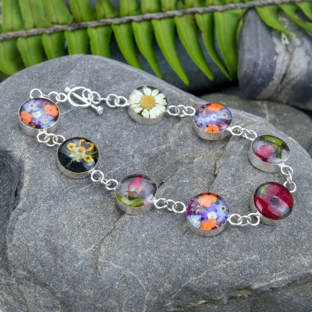san marco silver and resin bracelet with various coloured dried flowers encased in the resin of eight small round sections and joined by silver links