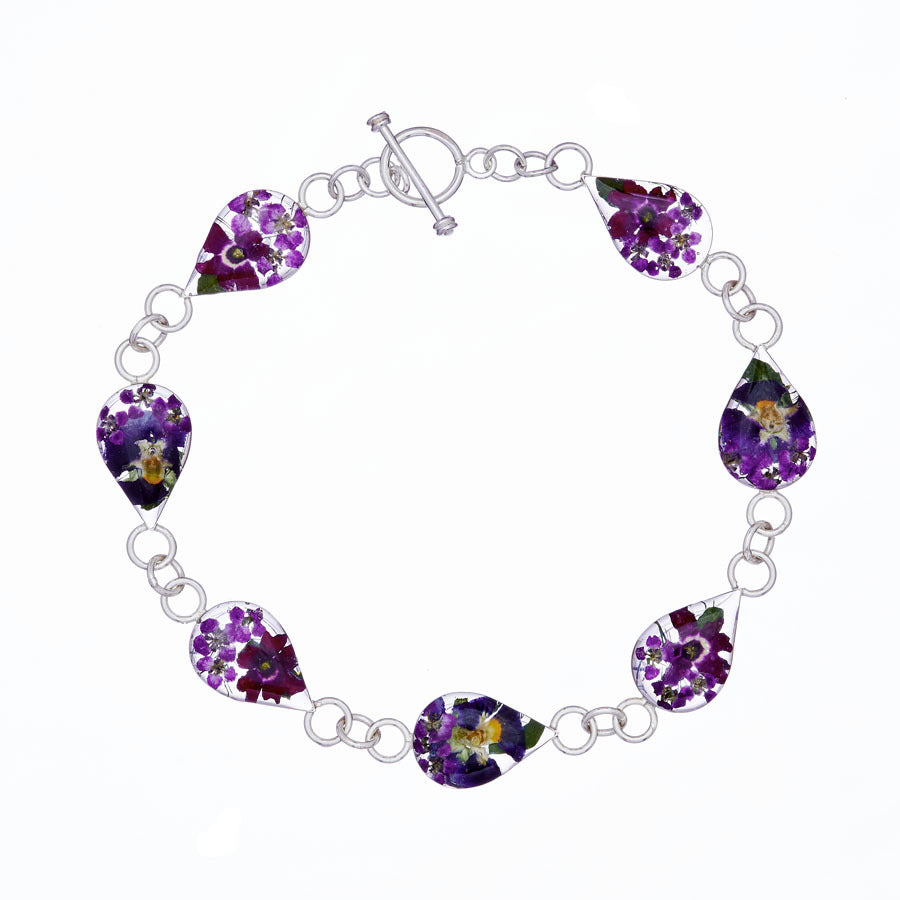 san marco silver and resin bracelet with purple dried flowers encased in the resin of seven small droplet shaped sections and joined by silver links