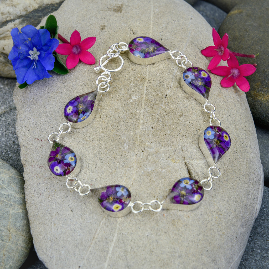 san marco silver and resin bracelet with purple dried flowers encased in the resin of seven small droplet shaped sections and joined by silver links