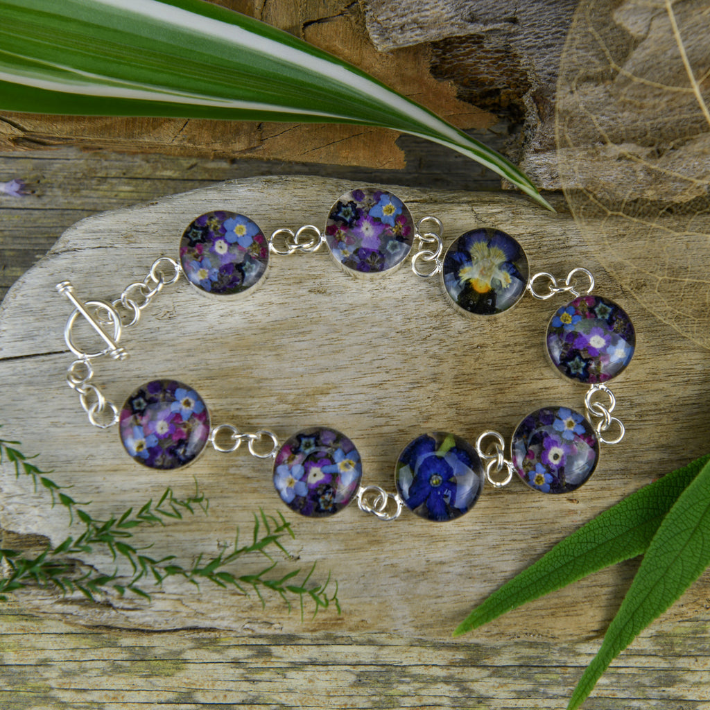 san marco silver and resin bracelet with purple and complementary toned dried flowers encased in the resin of eight small round sections and joined by silver links