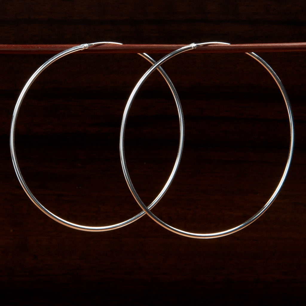sterling silver large hoop earrings on a wooden background